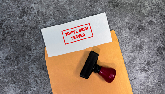 File Folder with document sticking out that says Youve Been Served stamped on it